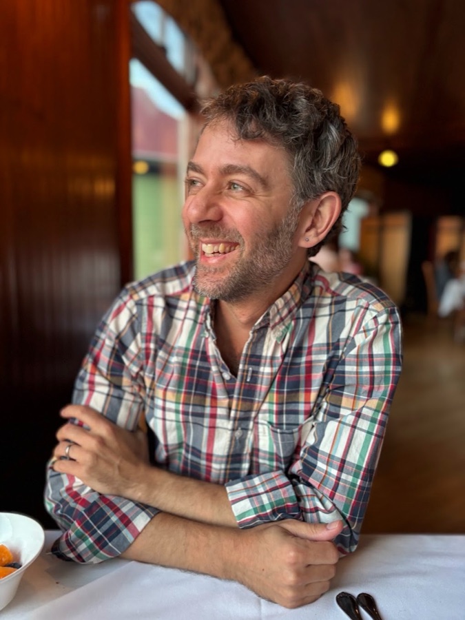 Jordan B. Warner smiling in a plaid shirt
